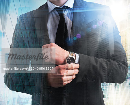 Elegant businessman with clock on skyscrapers background