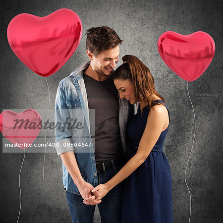 Smiling couple embracing with red heart balloons