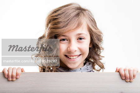 smiling and laughing little girl from behind a wooden fence