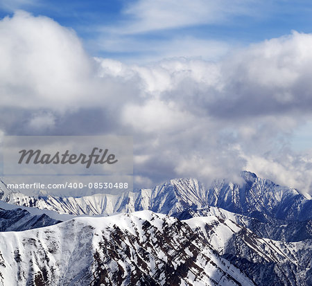 Winter snowy mountains and cloudy sky. Caucasus Mountains, Georgia, view from ski resort Gudauri.