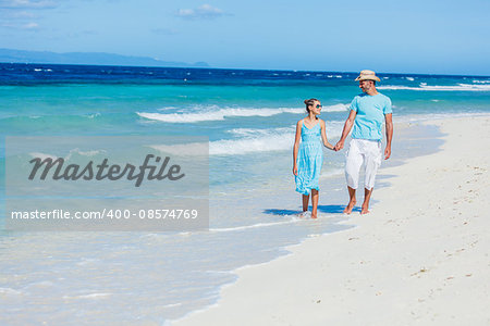 Father with his daughter walking on beautiful sunny beach