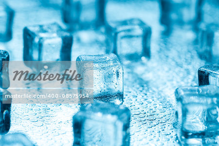 Many blue melting ice cubes on glass