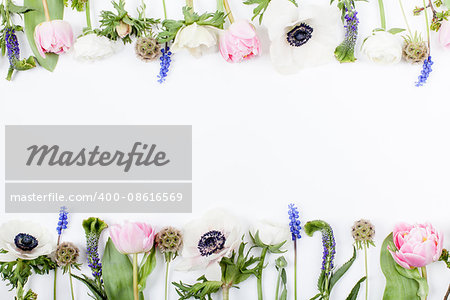 Pink tulips, white anemones, pink cloves and white buttercups lying on white background in two rows, on top and on the bottom