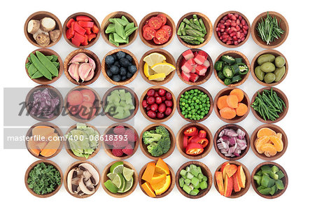 Paleolithic super health food of fruit and vegetables in wooden bowls over white wood background. High in vitamins, antioxidants, minerals and anthocyanins.