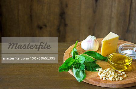 Sicilian basil pesto ingredients on wooden table with copypaste space