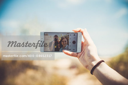 Happy couple makes selfie on a white phone