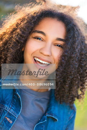 Outdoor portrait of beautiful happy mixed race African American girl teenager female young woman smiling laughing with perfect teeth