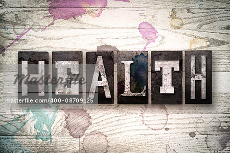 The word "HEALTH" written in vintage, dirty metal letterpress type on a whitewashed wooden background with ink and paint stains.