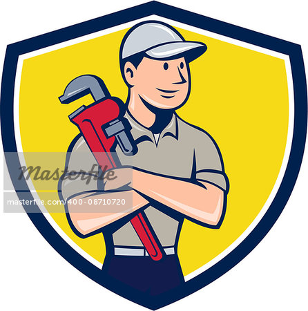 Illustration of a plumber wearing hat looking to the side arms crossed holding monkey wrench viewed from front set inside shield crest on isolated background done in cartoon style.