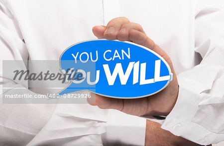 Hand holding a bubble speech where it is written you can and you will. Motivational concept for determination and willpower. Composite image between a photography and a 3D sign.