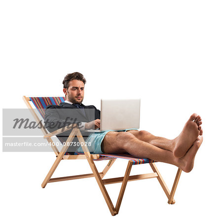 Businessman works with computer on a deckchair