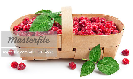 Fresh berries raspberry in wicker basket with green leaves, isolated on white background