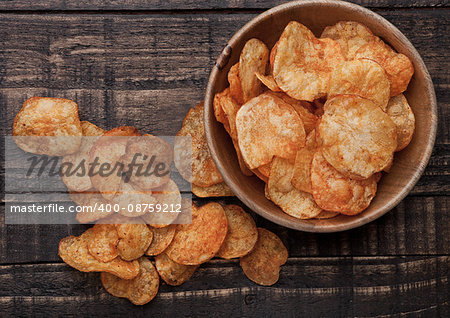 Bowl with potato crisps chips on wooden board. Junk food