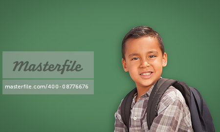Cute Hispanic Boy with Backpack In Front of Blank Chalk Board.