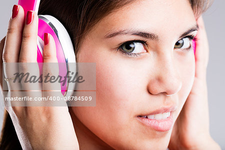 close up portrait of a young woman showing wonderful green big eyes while listening to her favourite music