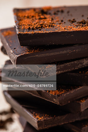 Stack of Chocolate Bars with red powder of chili pepper. vertical orientation.