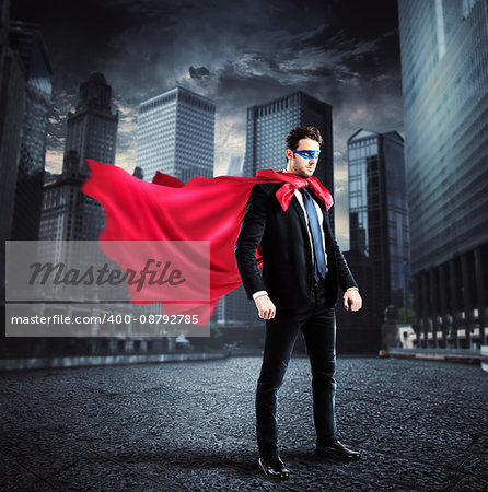 Businessman with a superhero cape and mask lands on the asphalt of a city street