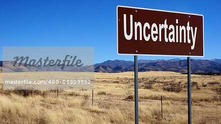 Uncertainty road sign with blue sky and wilderness