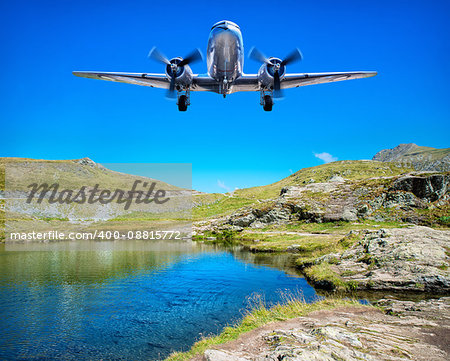 airplane flying over a lake in the mountains