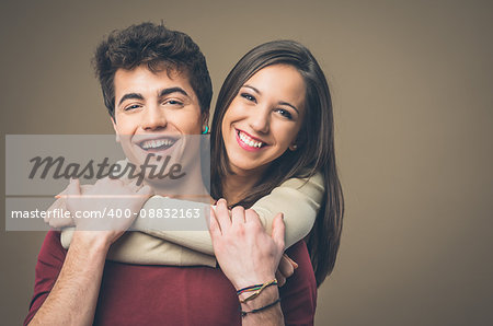 Happy young loving couple hugging and smiling at camera