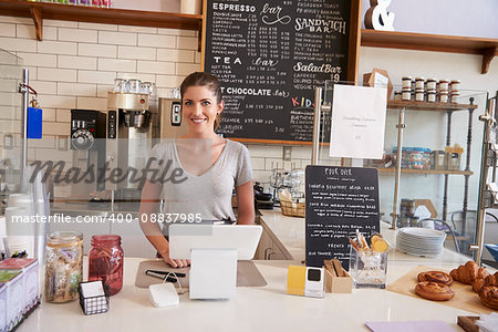 Woman waiting behind the counter at a coffee shop, close up