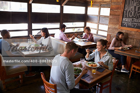 Couples relaxing over lunch in a restaurant, elevated view