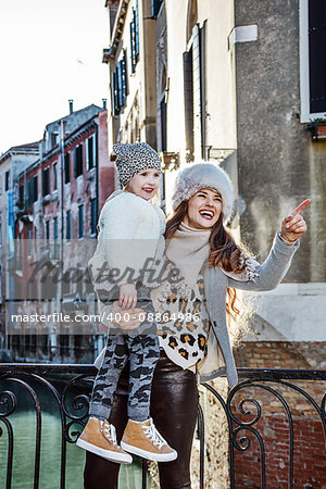Venice. Off the Beaten Path. happy trendy mother and child travellers in Venice, Italy in the winter sightseeing