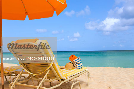 sunbeds with beach accessories and umbrella at picture perfect caribbean beach