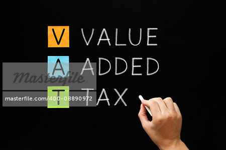 Hand writing VAT - Value Added Tax with white chalk on blackboard.