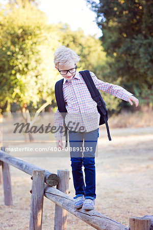 cute school boy student in glasses and with backpack enjoying time outdoor, back to school concept