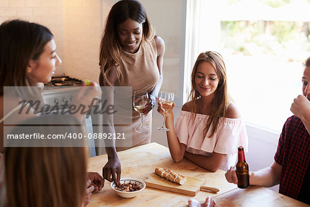 Four young women and a man at a casual dinner party, Ibiza