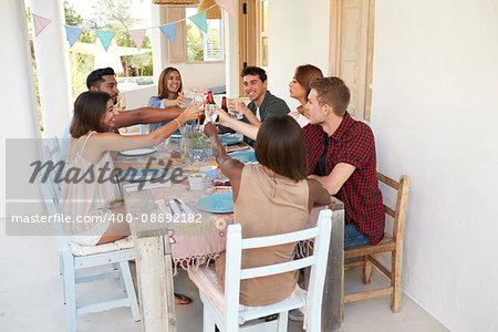 Friends making a toast at a dinner party on a patio, Ibiza