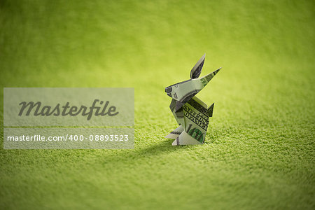 origami hare from banknotes a green background