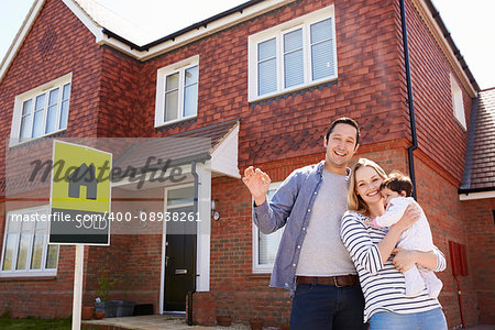 Portrait Of Young Family With Keys To New Home