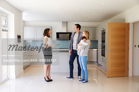 Realtor Showing Young Family Around Property For Sale