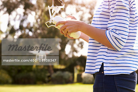 Close Up Of Woman Flying Drone Quadcopter In Garden