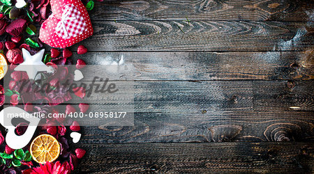 Valentine's Day Background with love themed elements like cotton and paper hearts, flowers, berries, oranges and other decorations. Wooden old parquet on the back.