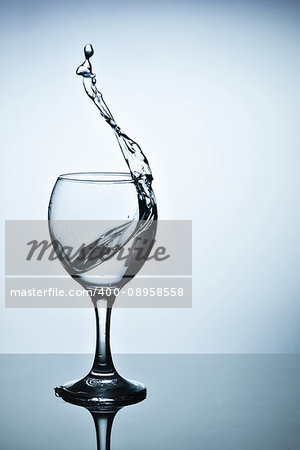 From a tall glass splashes water with a spray