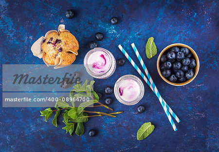 Natural yogurt with fresh blueberries, mint and a muffin. Top view. Selective focus.