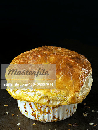 close up of rustic golden english meat pot pie with flaky crust