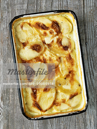 close up of rustic golden scalloped potato gratin dauphinois