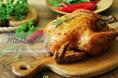 Whole roasted chicken with herb on cutting board