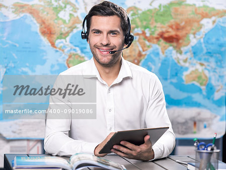 Young man tour agent sitting in office