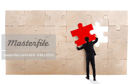 Businessman complete a puzzle inserting a missing piece