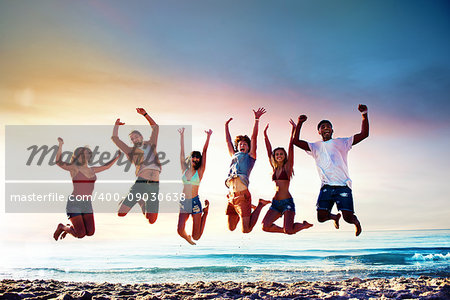 Happy smiling friends jumping over the sea of the beach