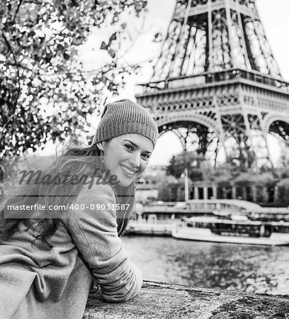 Autumn getaways in Paris. Portrait of smiling young tourist woman on embankment in Paris, France