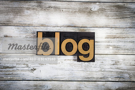 The word "blog" written in wooden letterpress type on a white washed old wooden boards background.