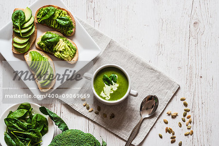 Vegetarian healthy food. Soup and vegan sandwiches. Different sandwiches with avocado. Brunch on white wooden background.