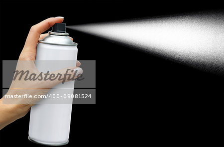 The dispersion jet from an aerosol can in feminine hand on dark background