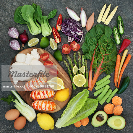 Diet health food concept with high protein meat and fish, vegetables, fruit, and dairy. Superfoods high in omega 3, antioxidants, anthocyanins, vitamins and fiber. Rustic background on marble top view.